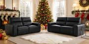 wo black leather electric recliner sofas facing each other in a cozy living room decorated for Christmas