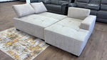 Gray sectional sofa on a wooden floor with a patterned rug.